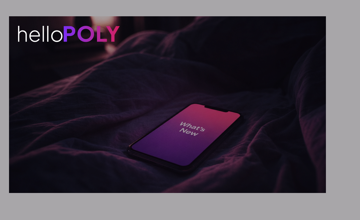Smartphone placed on a bed with a magenta-lit screen showing the text "What's New" and the helloPOLY wordmark